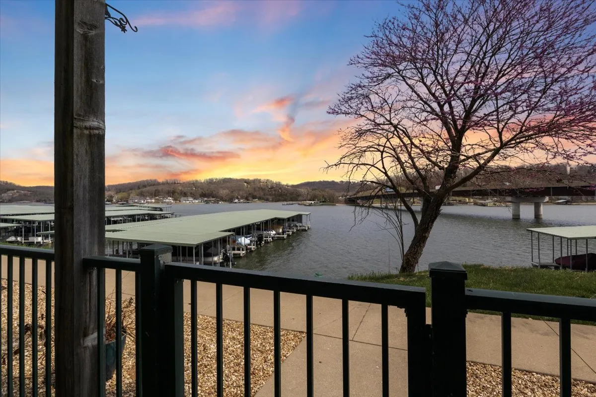 A picturesque sunset over the lake with docks and a lone tree in sight. The image conveys a peaceful, nature-immersed environment ideal for quiet evenings, lakeside yoga, or simply unwinding after a day of exploring the nearby state park.