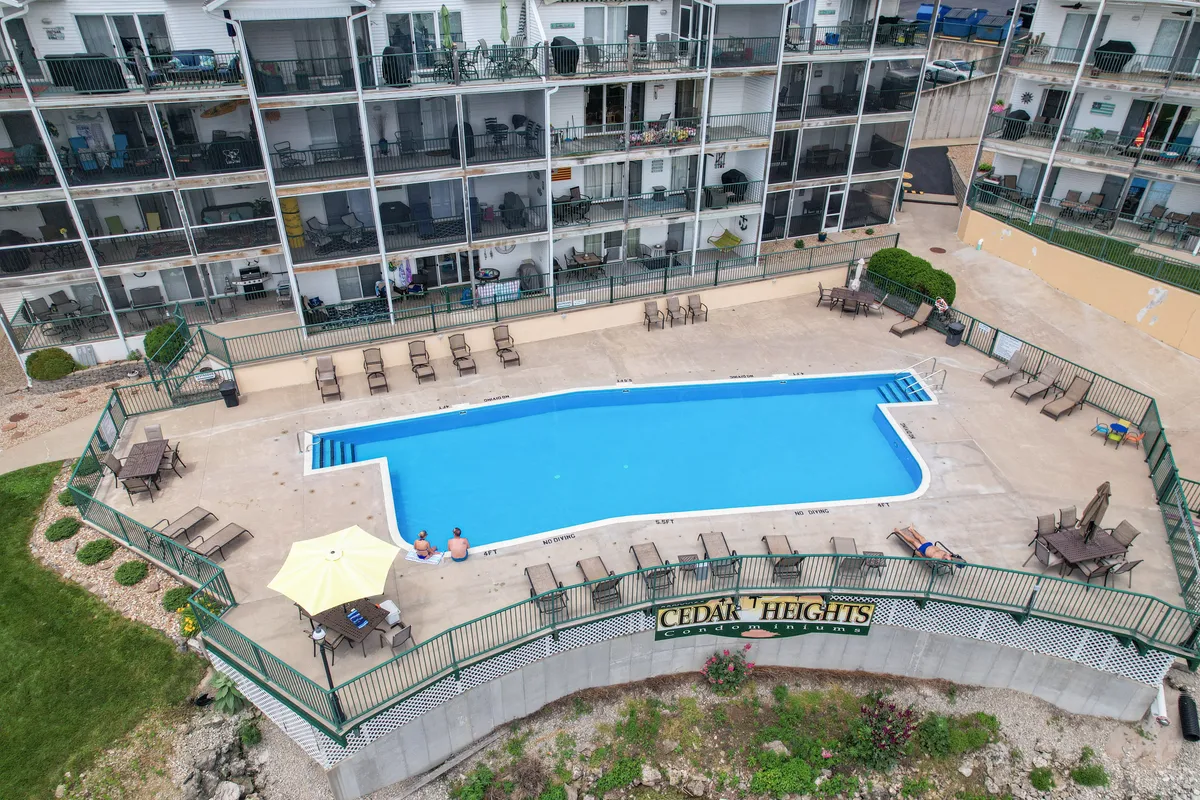 This image showcases one of the community swimming pools, surrounded by lounge chairs and balconies from the building. The setting is perfect for group relaxation and socializing, with open skies hinting at sunset ambiance.
